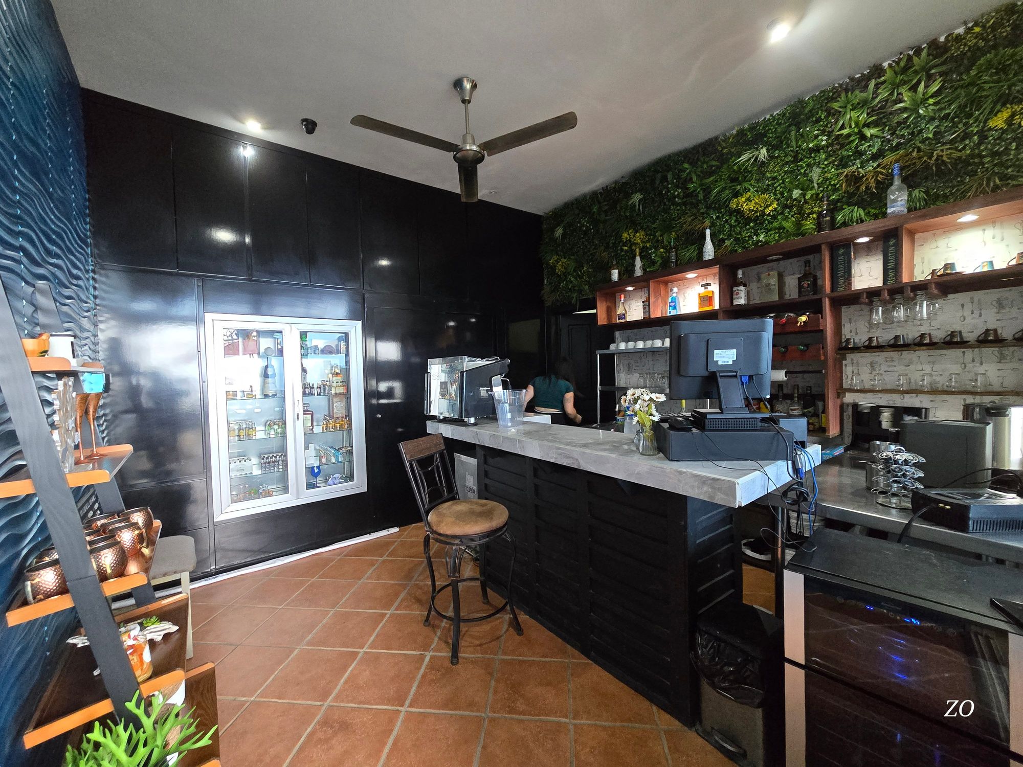 The Vista Bistro bar, with a living plant wall, bottles, and the espresso machine
